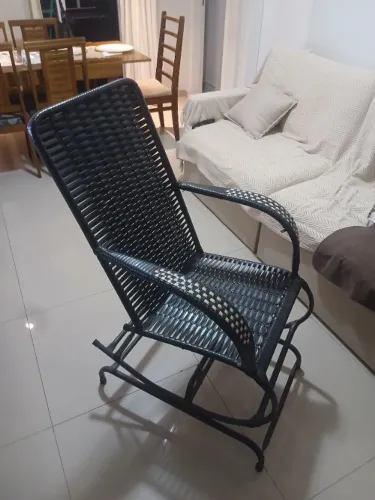 Cadeira de balanço com estrutura metálica com encosto e assento trançados