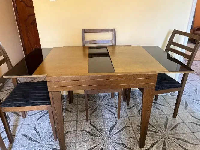 Mesa de jantar 4 e 6 lugares com 4 cadeiras em estofado preto.