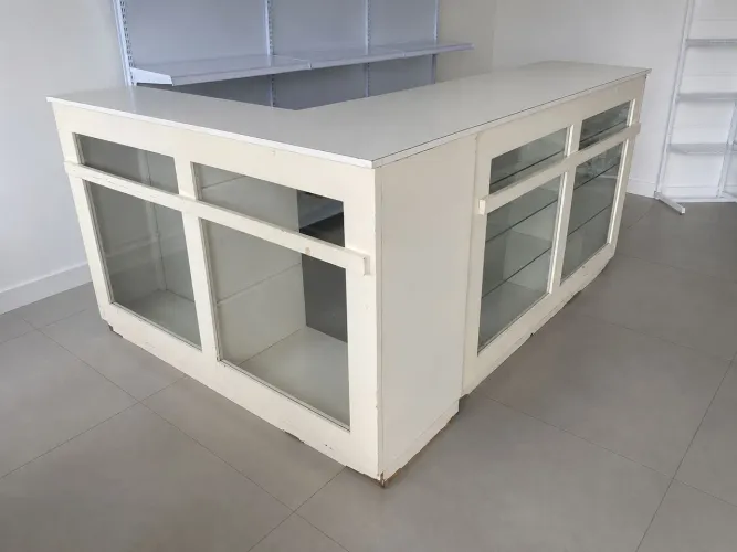 Balcão branco com prateleiras de vidro