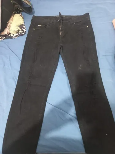 Calça jeans preta Colcci, com rasgos e detalhes destroyed. Estilo urbano e autêntico!