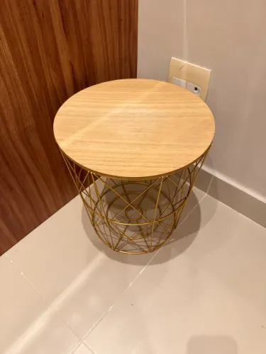 Mesa com tampo de madeira e estrutura metálica dourada