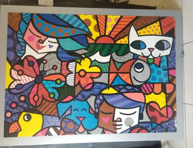 Quebra cabeça montado Romero Brito colado na placa