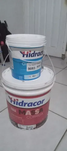 Um balde de massa corrida e um galão de fundo preparador 