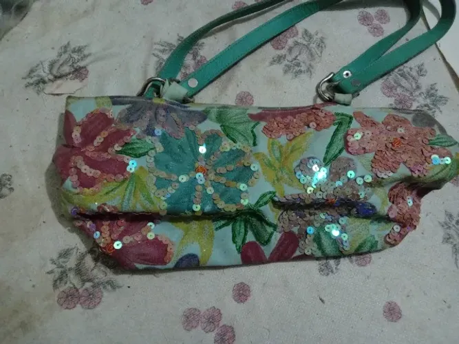 Bolsa feminina com designers florais e detalhes brilhantes 