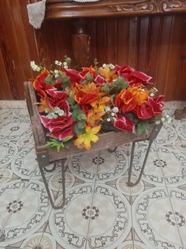Arranjo de flores ma caixa antiga e tripé de ferro rústico