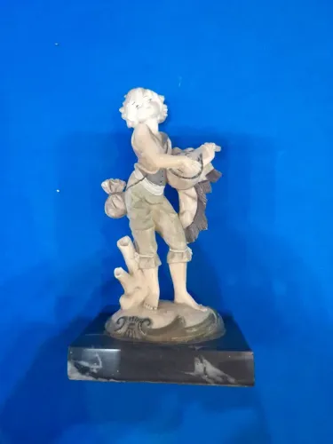 Estátua de menino tocando instrumento