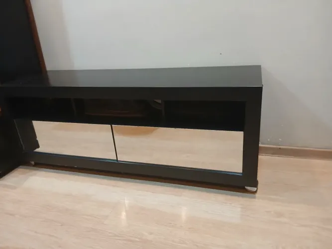 Rack preto com rodinhas e dois gavetões espelhados e três nichos.