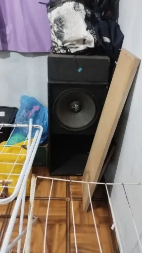 Caixa de som profissional e bateria.