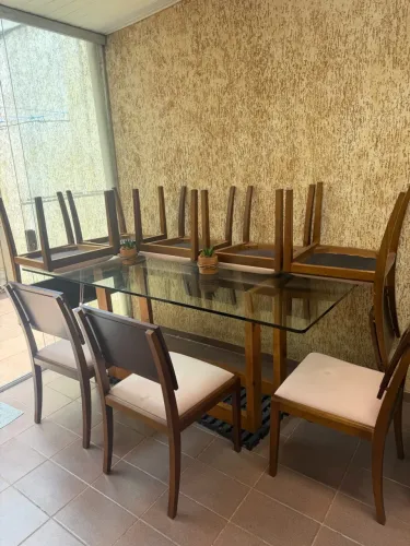 Mesa de vidro com base em madeira e 8 cadeiras