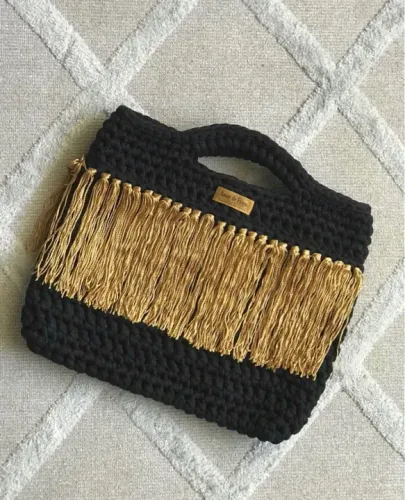 Bolsa de em fio de malha preta com franjas douradas