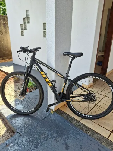 Bicicleta GT aro 29: MTB preta e amarela com freio a disco