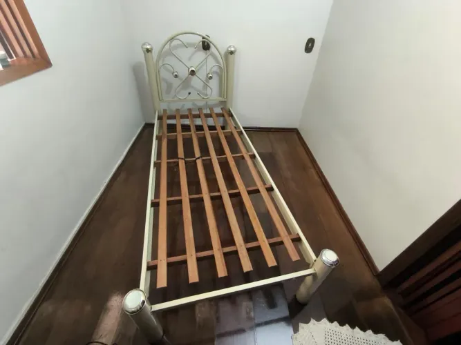 Cama de solteiro de metal com estrado de madeira