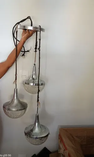 Luminária de teto, pendente, com três peças em metal e vidro.