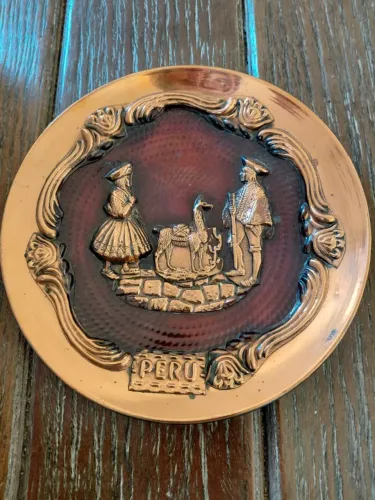 Prato decorativo peruano em cobre. Cena central em relevo com figuras típicas