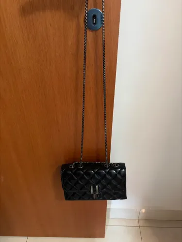 Bolsa preta matelassê transversal com corrente