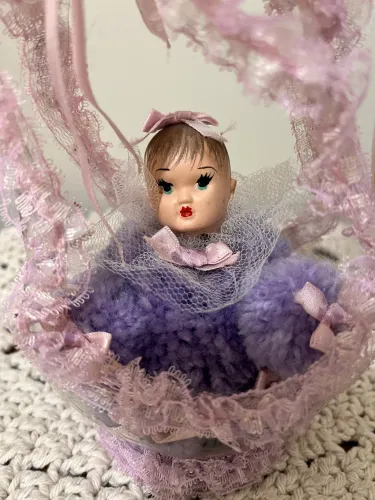 Boneca de porcelana na cesta.