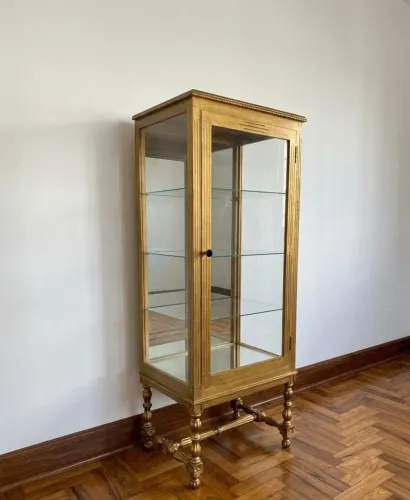 Cristaleira em madeira com acabamento dourado e laterais em vidro