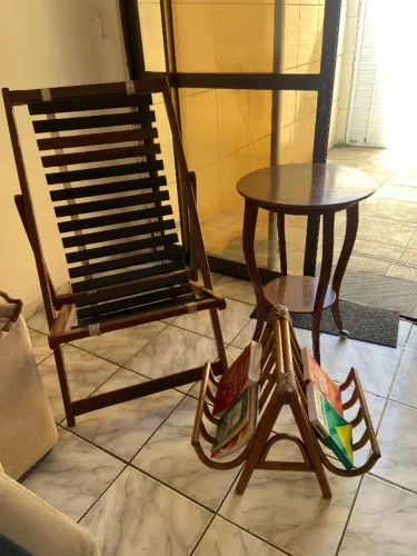 Cadeira em madeira , mesa de canto e expositor de livros e revistas.