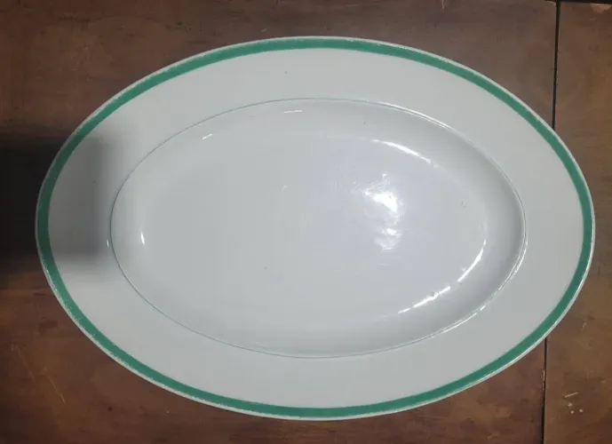 Travessa oblonga antiga de porcelana, caracterizada por sua cor branca com filete verde