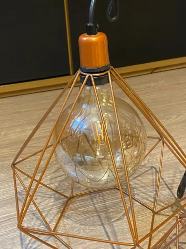 Três luminárias pendentes aramadas em formato de diamante na cor cobre (rose gold)