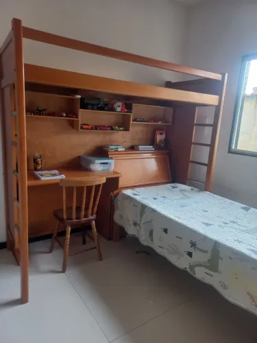 Cama beliche de madeira maciça com escrivaninha e a cadeira e baú.