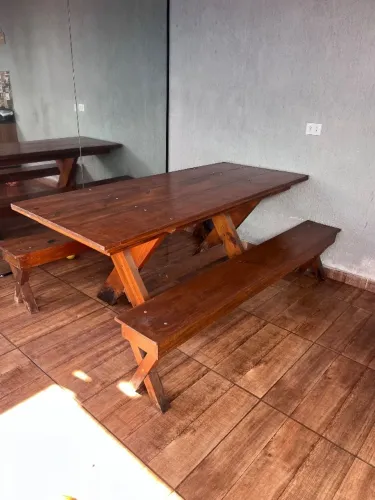 Mesa de madeira com bancos e banquetas