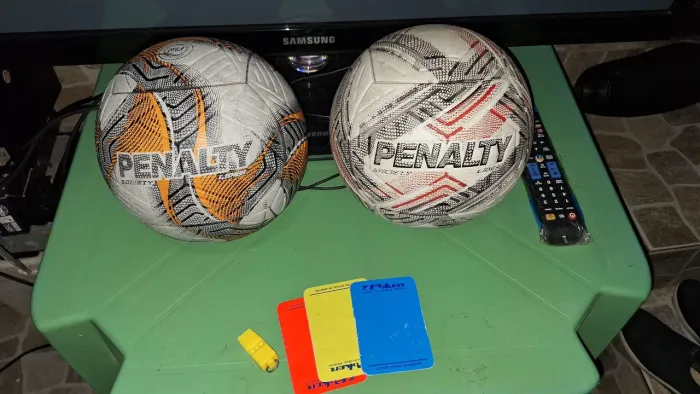 Vendo 2 bolas da penalty um jogo de cartões e um apito.