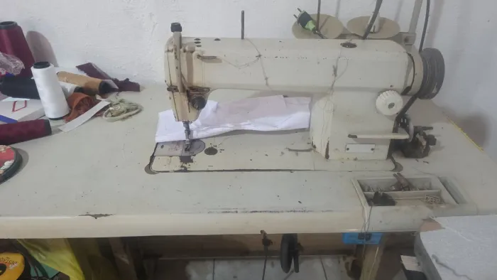 Máquina industrial de custura reta funcionando