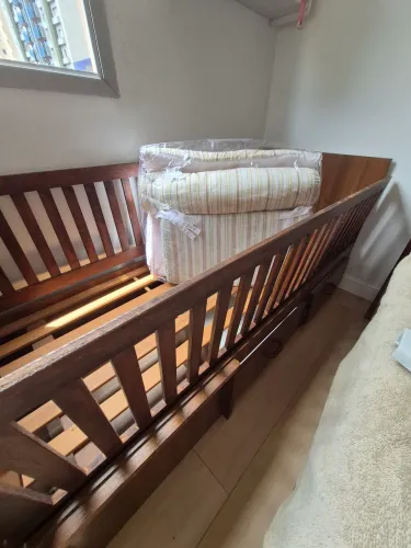 Berço de madeira com gavetas e decoração