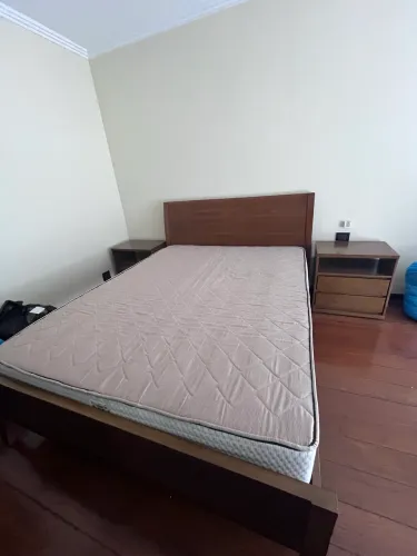 Cama queen com mesas de cabeceira e cômoda 