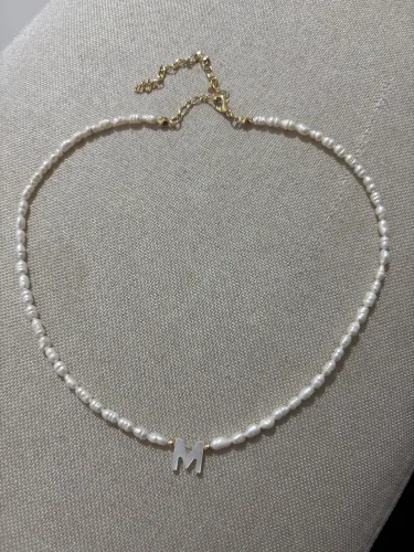 Colar de pérola com letra M.