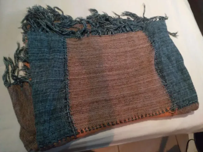 Cobertor artesanal de tecido com detalhes em azul e franjas