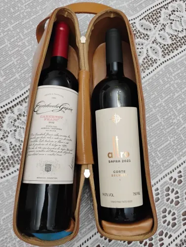 Case porta duas garrafas de vinho em couro cor bege com sacola de transporte na cor crú.