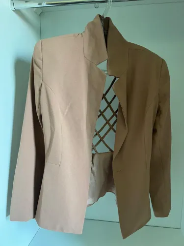 Blazer feminino de alfaiataria bege com recortes nas costas