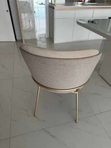 Cadeira bege com acabamento dourado 