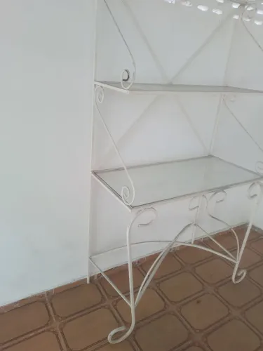 Linda estante de ferro com prateleira de vidro.