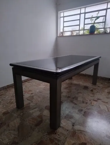 Mesa de 6 a 8 lugares em laca com tampo de vidro fumê.