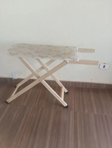 Tábua de passar roupa com tampo de madeira. 