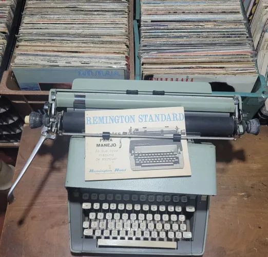 máquina de escrever da marca Remington acompanhada pelo seu manual de instruções original.