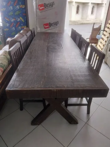 Mesa de madeira maciça com oito cadeiras.