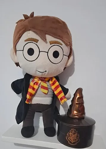 pelúcia do personagem Harry Potte e uma lata em formato de chapéu da cacau show