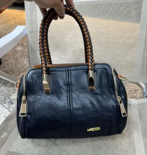 Bolsa Baú média preta com alça transversal em couro sintético. 