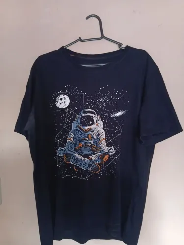 Camiseta Astronauta Meditando. ORIGINAL BLUE STELL. RENNER BRILHA NO ESCURO. TAMANHO M.