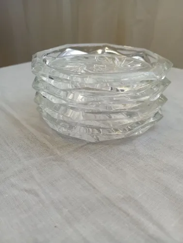 Vendo jogo com 4 porta-copos de vidro prensado lapidado, mede 9cm de diâmetro.