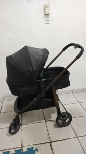Carrinho de bebê com bebê conforto e base