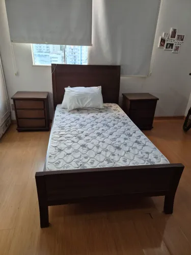 Cama de viúvo acompanhada de duas mesas de cabeceira