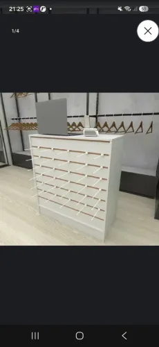 Balcão branco de loja, com painel canelado.