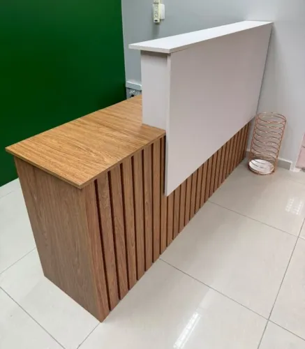 Balcão de recepção com acabamento amadeirado e ripado