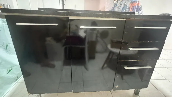 Balcão preto com gaveteiros, de cozinha.