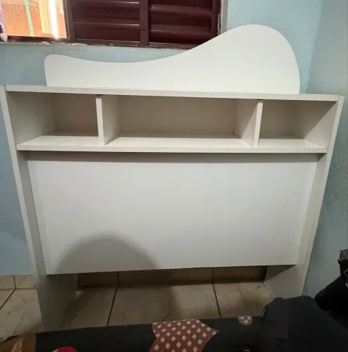 Cabeceira branca com nichos, ideal para quarto de solteiro.